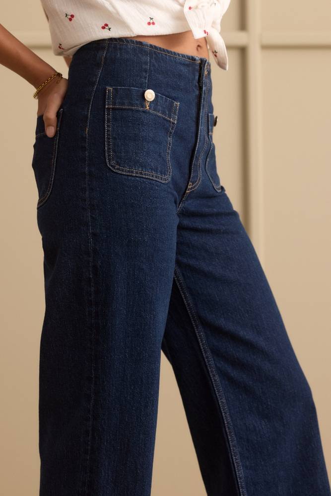 Nærbilde av mørkeblå høytlivs jeans som viser lommedetaljer.