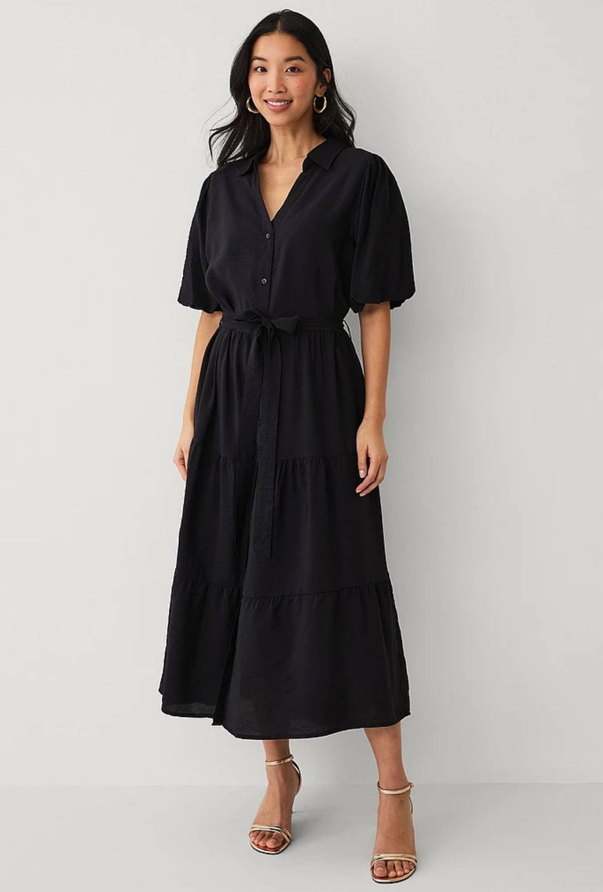 Sort skjortekjole med korte pufærmer.