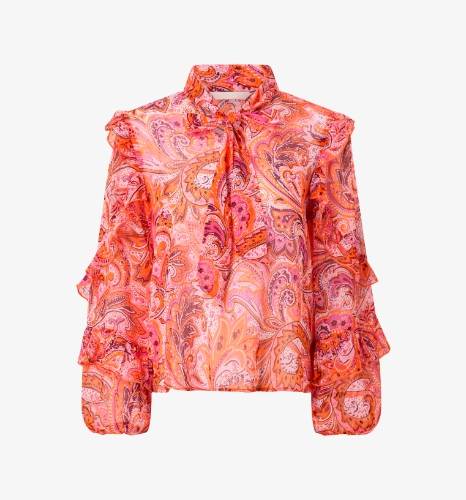 Orange mønstret bluse med flæser og bindebånd i halsen.