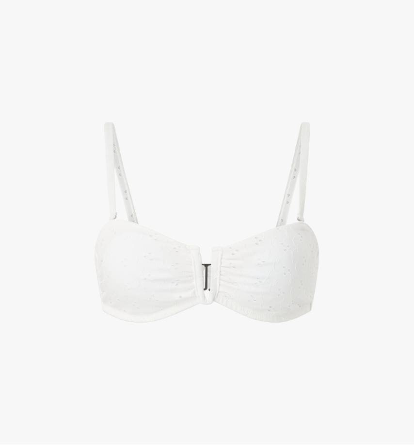 Valkoinen bandeau-mallinen bikiniyläosa, jossa on ohuet olkaimet ja koristeellinen metallirengas edessä.