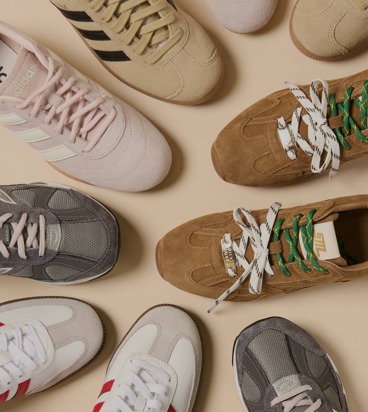 Flere sneakers i ulike farger og modeller plassert mot lys bakgrunn, sett ovenfra.