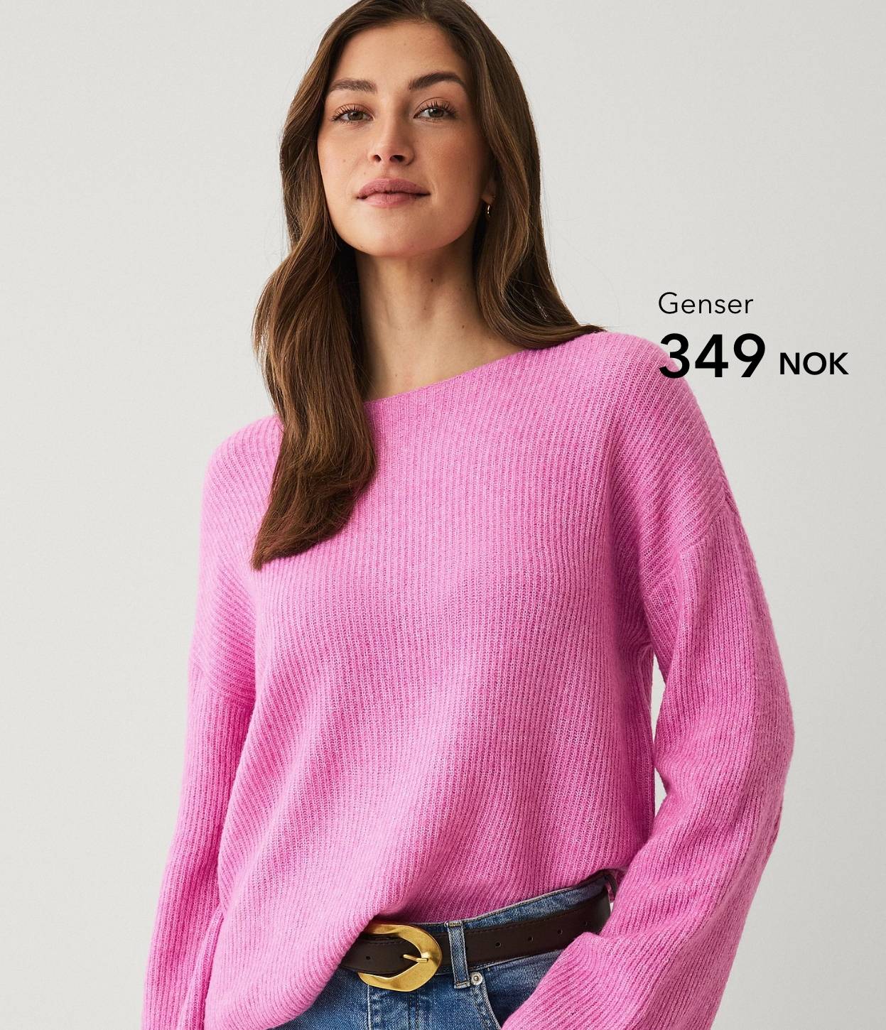 Kvinne i rosa strikkegenser mot lys bakgrunn.