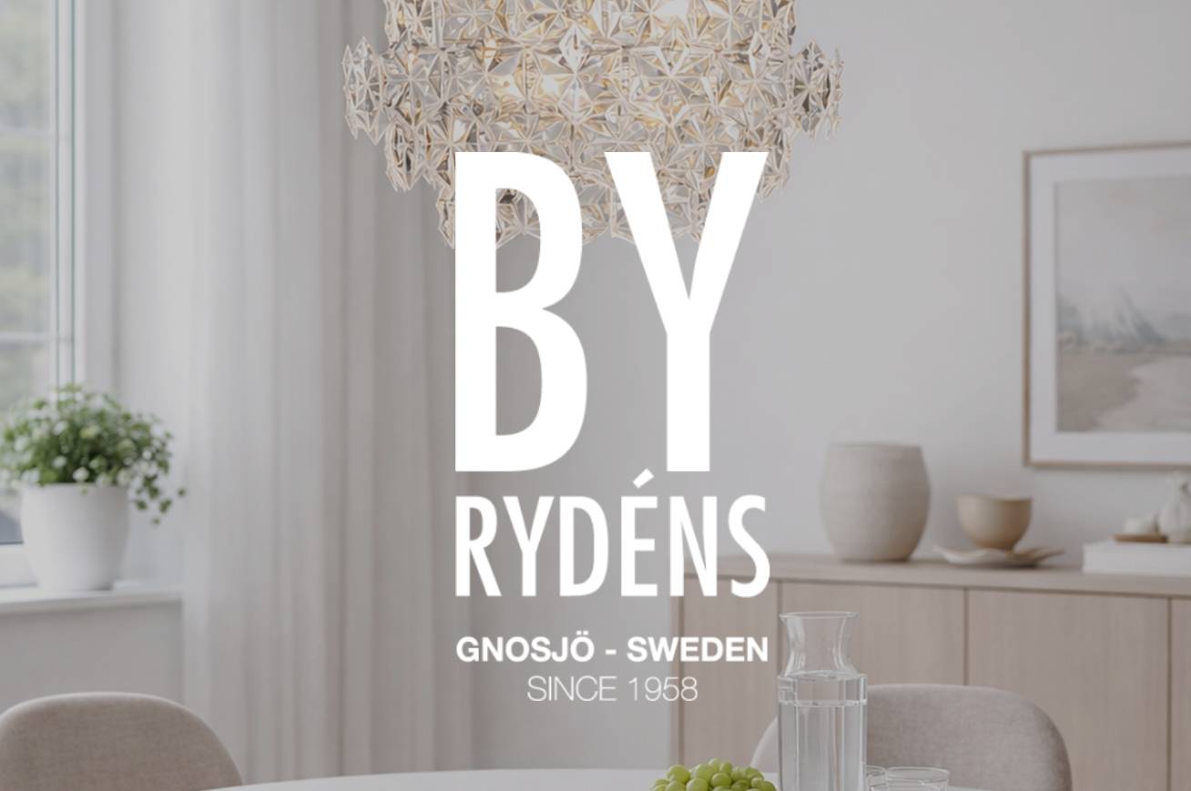 Kattovalaisin huoneessa pöydän ja sisustuksen kanssa, By Rydéns -logo näkyvissä.