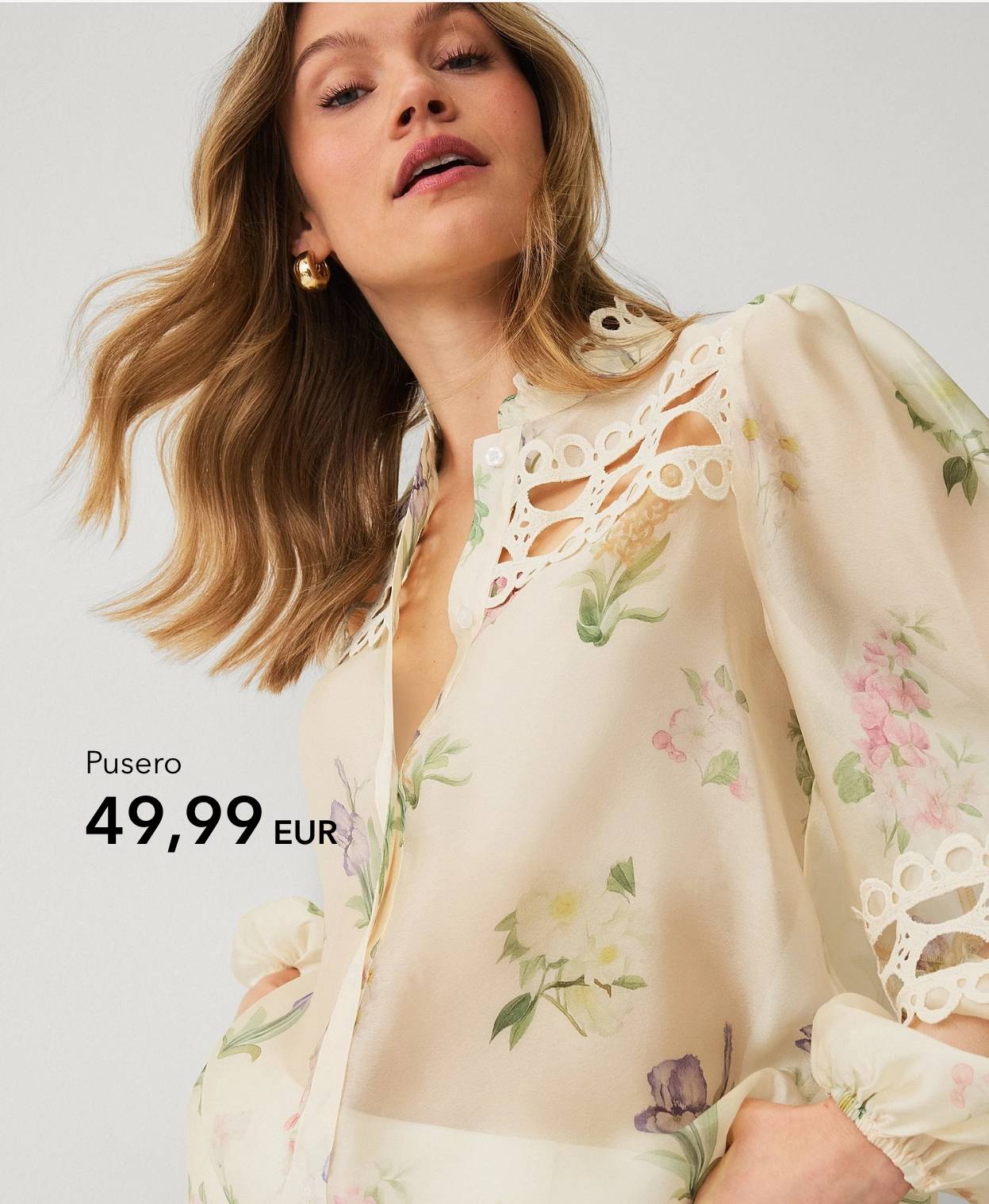 Nainen vaaleassa kukkakuosisessa puserossa, jossa pitsiyksityiskohtia.