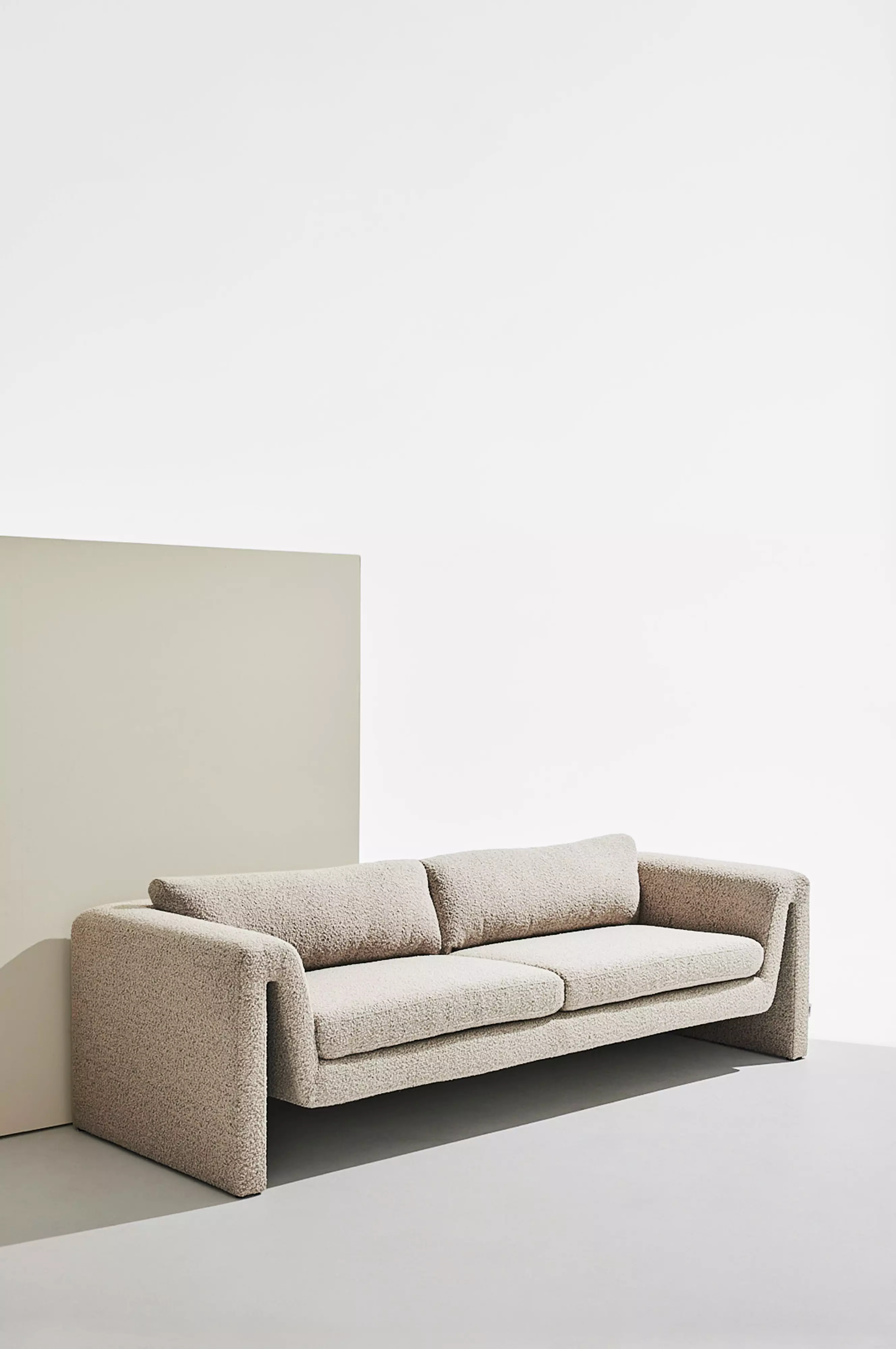 Beige böljande tresitssoffa i bouclé